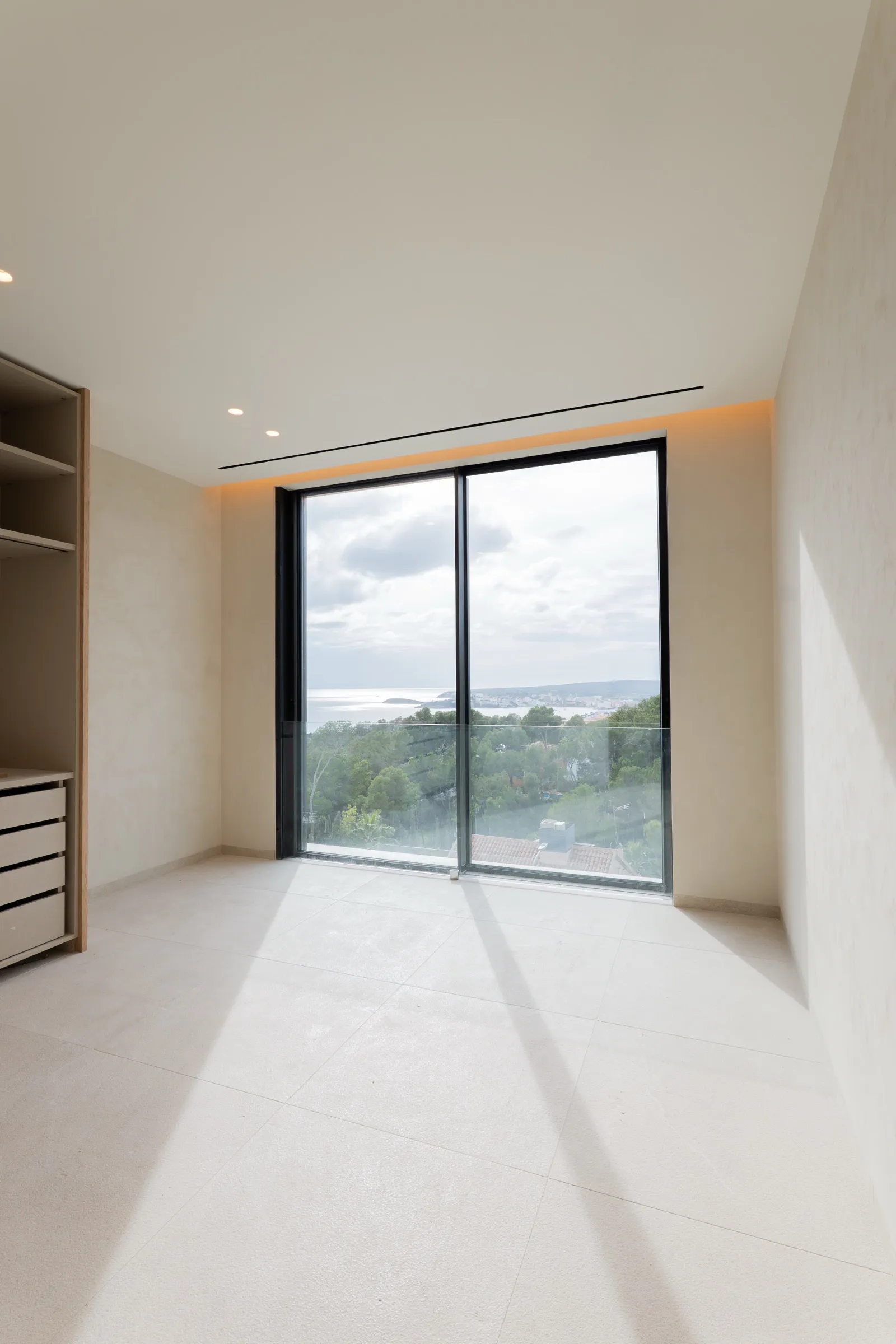 Vestidor con falso techo LED perimetral y vistas al mar